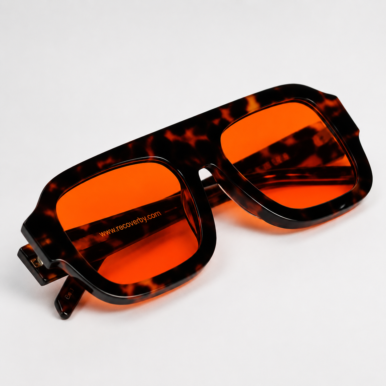 Tortoiseshell blue light blocking glasses with bright orange lenses, shown at an angle on a clean white background.