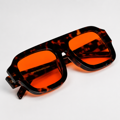 Tortoiseshell blue light blocking glasses with bright orange lenses, shown at an angle on a clean white background.