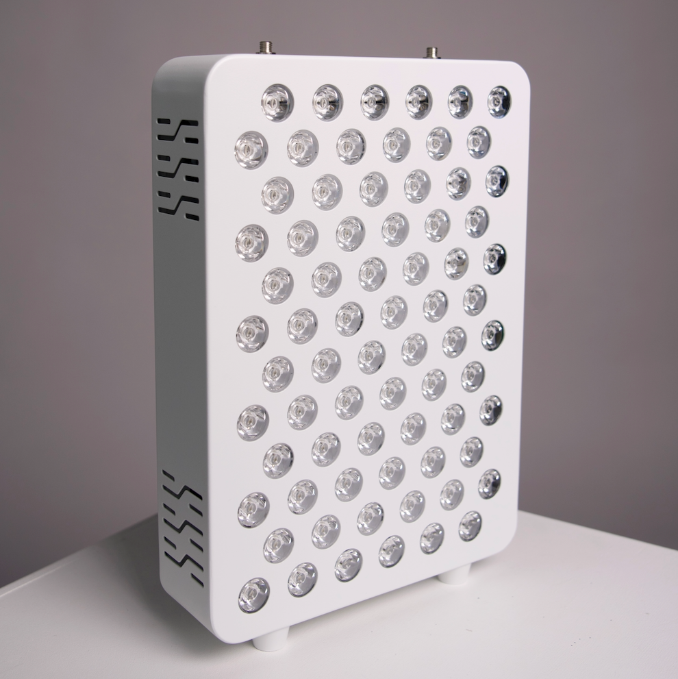 A white rectangular Red light panel LED  with multiple circular clear lenses arranged in a grid, standing on a white surface against a gray background.
